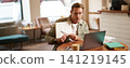 Portrait of young handsome man in glasses, private tutor teaching student online, pointing at his notebook, showing something, video chats via laptop application, working remotely in cafe 141219145