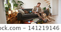 Man with a dog sitting near suitcase, holding notebook, checking list of items to take on vacation, planning a holiday trip 141219146