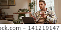 Portrait of man with serious face, sitting in cafe with laptop and smartphone, pointing at you with warning, scolding you, frowning with disapproval 141219147