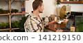 Portrait of freelancer, young man with laptop in coffee shop, paying for his order, pressing his credit card to the POS terminal, contactless payment concept 141219150