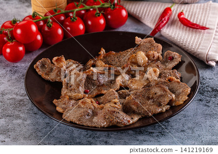 Grilled beef slices with cherry tomatoes and red chili peppers on dark plate Grilled beef slices with cherry tomatoes and red chili peppers on dark plate 141219169