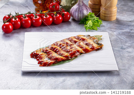 Grilled fish fillet with cherry tomatoes and garlic on white plate Grilled fish fillet with cherry tomatoes and garlic on white plate 141219188