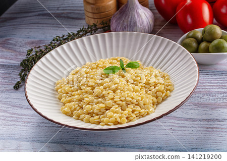 Pasta dish with basil garnish on rustic wooden table 141219200
