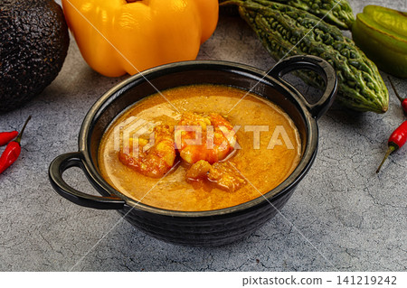 Spicy shrimp curry in black bowl with fresh vegetables Spicy shrimp curry in black bowl with fresh vegetables 141219242