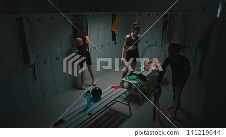 Teen Gymnasts Spending Time and Talking inside Dark Studio Locker Room Teen Gymnasts Spending Time and Talking inside Dark Studio Locker Room 141219644