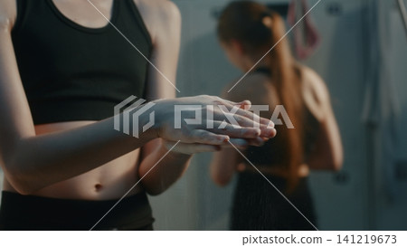 Focused Young Athlete Using Chalk inside Studio Dressing Room 141219673