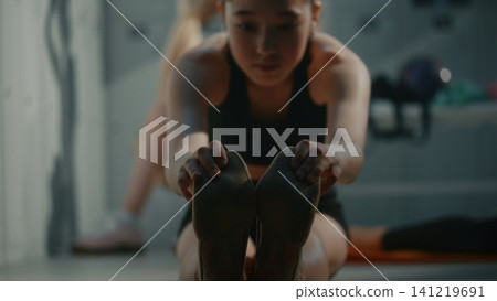 Teen Gymnast Practicing Seated Forward Fold Bending in Dressing Room Teen Gymnast Practicing Seated Forward Fold Bending in Dressing Room 141219691