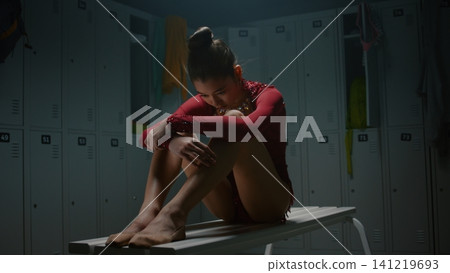 Sad Teenage Rhythmic Gymnast Experiencing Panic Attack in Empty Locker Room Sad Teenage Rhythmic Gymnast Experiencing Panic Attack in Empty Locker Room 141219693