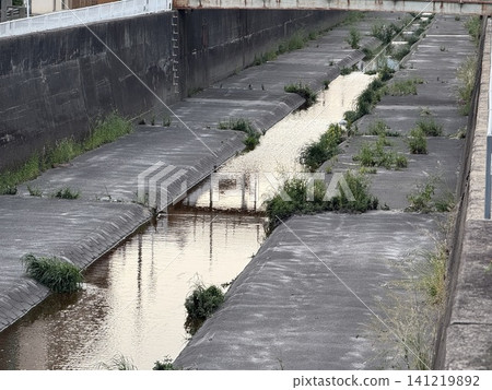 A small urban river flowing through a residential area. A small urban river flowing through a residential area. 141219892
