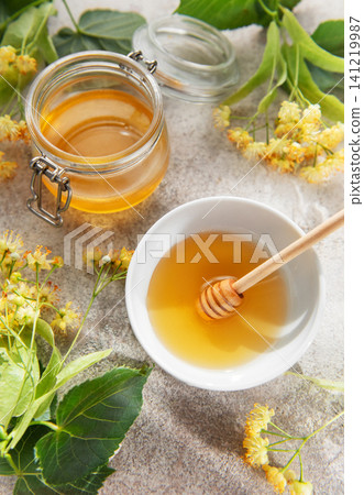 Linden honey jar and bowl with fresh flowers Linden honey jar and bowl with fresh flowers 141219987