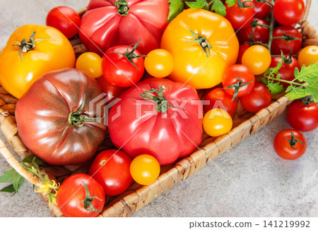 Heirloom tomatoes in a basket showing harvest variety Heirloom tomatoes in a basket showing harvest variety 141219992