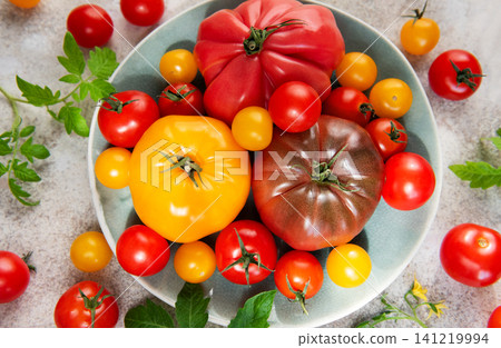Fresh farm tomatoes displaying colorful variety on a plate 141219994