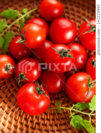 Cherry tomatoes resting in rustic wicker basket Cherry tomatoes resting in rustic wicker basket 141219995