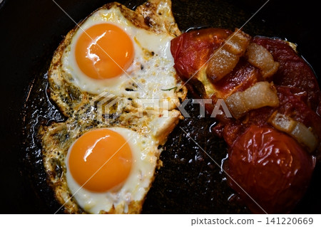 Morning bowl of fluffy scrambled eggs topped with fresh tomatoes and basil on a rustic wood table Morning bowl of fluffy scrambled eggs topped with fresh tomatoes and basil on a rustic wood table 141220669