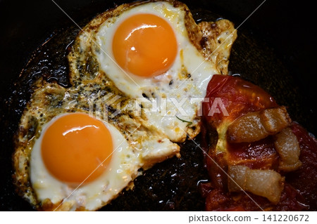 Morning bowl of fluffy scrambled eggs topped with fresh tomatoes and basil on a rustic wood table Morning bowl of fluffy scrambled eggs topped with fresh tomatoes and basil on a rustic wood table 141220672