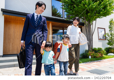 A family of four leaves the house with smiles on their faces. A family of four leaves the house with smiles on their faces. 141220704