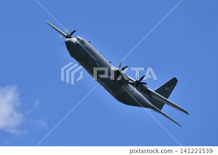 A US military C-130 Hercules aircraft flying at low altitude. A US military C-130 Hercules aircraft flying at low altitude. 141221539