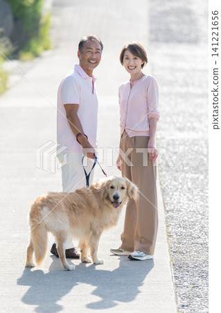 Senior couple walking a dog Senior couple walking a dog 141221656