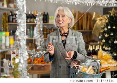 Visiting store on New Years Eve, elderly woman is looking at something on shelf of showcase. Visiting store on New Years Eve, elderly woman is looking at something on shelf of showcase. 141223150