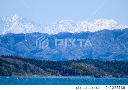 The Northern Alps, their snow-capped peaks shining brightly across Nanao Bay The Northern Alps, their snow-capped peaks shining brightly across Nanao Bay 141223186