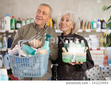 elderly couple chooses goods in a household chemicals store elderly couple chooses goods in a household chemicals store 141223443
