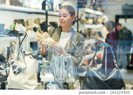 Young woman choosing loafers in shoe store 141223505
