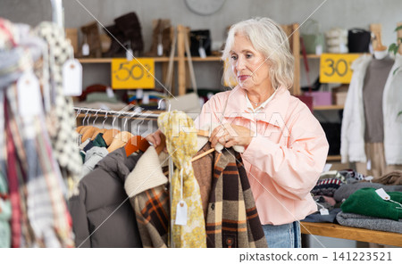pensioner woman chooses a woolen coat pensioner woman chooses a woolen coat 141223521