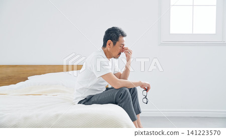 A senior man suffering from stiff shoulders. Fatigue, tiredness, bed, middle age, middle-aged and older, stress, aging, feeling down, disappointed. A senior man suffering from stiff shoulders. Fatigue, tiredness, bed, middle age, middle-aged and older, stress, aging, feeling down, disappointed. 141223570