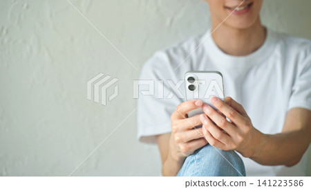 A man using a smartphone. Apps, social media, videos, email, digital transformation, games, relaxation, young people, search, smartphone A man using a smartphone. Apps, social media, videos, email, digital transformation, games, relaxation, young people, search, smartphone 141223586