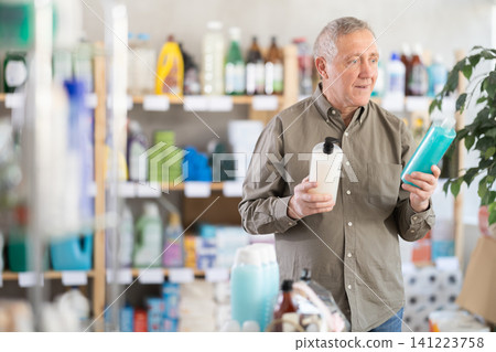 Elderly man choosing shampoo and shower gel Elderly man choosing shampoo and shower gel 141223758