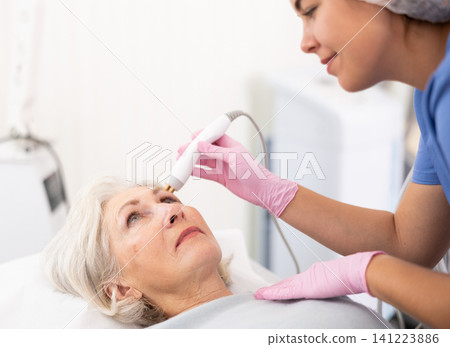 Old woman having face radiolifting procedure Old woman having face radiolifting procedure 141223886