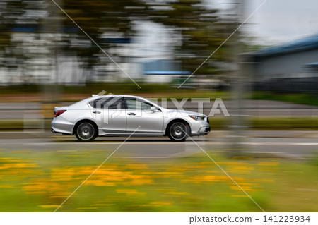 A silver sedan driving through the suburbs A silver sedan driving through the suburbs 141223934