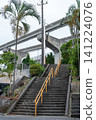 A staircase with a handrail in the center and a monorail track. 141224076