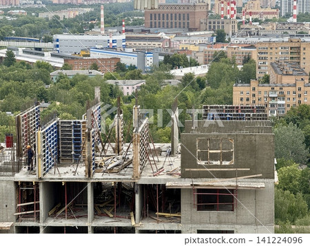 Construction site building construction, in urban area with industrial buildings and greenery in, with concrete structures, scaffolding, construction materials, worker, with gray, blue accents. 141224096