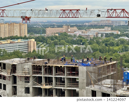 Construction site building construction, in urban area with greenery in the background, with workers, cranes, building structure, concrete blocks, with concrete, steel rebar texture. 141224097