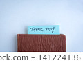 Handwritten Thank you slit between a book. 141224136