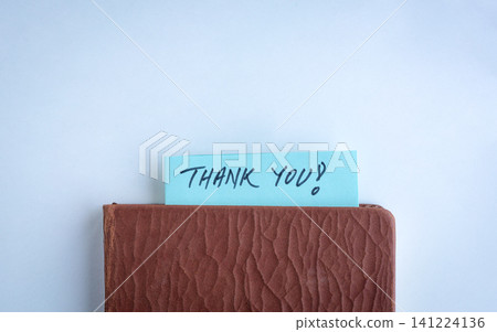 Handwritten Thank you slit between a book. Handwritten Thank you slit between a book. 141224136