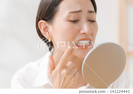 A young woman suffering from oral problems 141224441