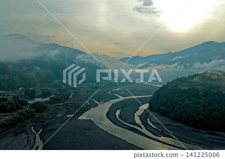 An aerial photograph taken at dawn in summer, capturing the Tanoguchi settlement and the Oigawa Valley in Shizuoka Prefecture. An aerial photograph taken at dawn in summer, capturing the Tanoguchi settlement and the Oigawa Valley in Shizuoka Prefecture. 141225006