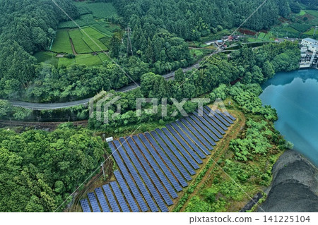 An aerial photograph showing solar panels, tea plantations, and a river in the Shiozato area of Shizuoka Prefecture. 141225104