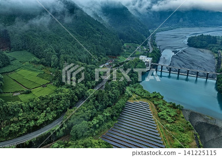 空拍照片捕捉了靜岡縣鹽里市周圍的水壩、太陽能板和茶園。 空拍照片捕捉了靜岡縣鹽里市周圍的水壩、太陽能板和茶園。 141225115
