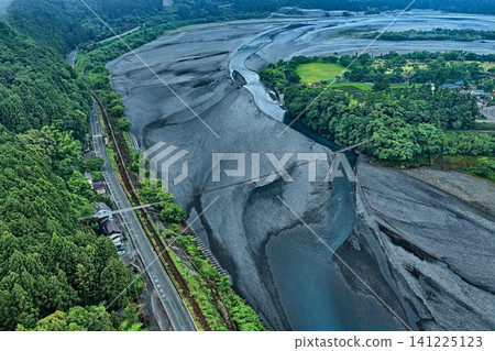 An aerial photograph overlooking the gravel riverbed, railway, and road along the Oi River in Shizuoka Prefecture. An aerial photograph overlooking the gravel riverbed, railway, and road along the Oi River in Shizuoka Prefecture. 141225123