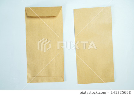 Top-down view of two blank brown kraft paper envelopes arranged on a light blue textured background, perfect for stationery mockups Top-down view of two blank brown kraft paper envelopes arranged on a light blue textured background, perfect for stationery mockups 141225698
