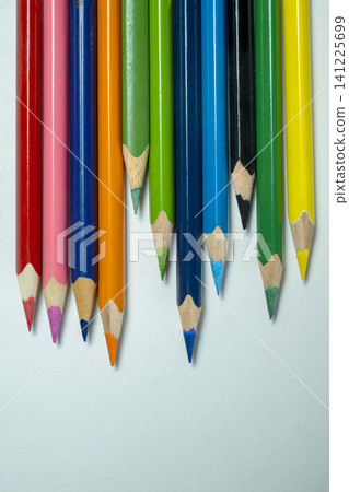 A close-up view of various vibrant colored pencils arranged in a staggered row on a light background, symbolizing creativity and education A close-up view of various vibrant colored pencils arranged in a staggered row on a light background, symbolizing creativity and education 141225699