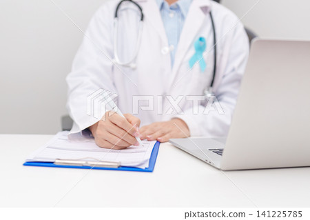 doctor using laptop and report notes on notebook. blue Ribbon concept of November Prostate Cancer Awareness month, Diabetes day , Men Health, International men, Father day. world cancer day doctor using laptop and report notes on notebook. blue Ribbon concept of November Prostate Cancer Awareness month, Diabetes day , Men Health, International men, Father day. world cancer day 141225785