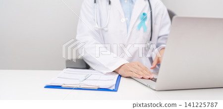 doctor using laptop and report notes on notebook. blue Ribbon concept of November Prostate Cancer Awareness month, Diabetes day , Men Health, International men, Father day. world cancer day doctor using laptop and report notes on notebook. blue Ribbon concept of November Prostate Cancer Awareness month, Diabetes day , Men Health, International men, Father day. world cancer day 141225787