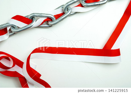 Metal chain wrapped in a red and white ribbon on a white background, symbolizing Indonesian independence, captivity, and national struggle Metal chain wrapped in a red and white ribbon on a white background, symbolizing Indonesian independence, captivity, and national struggle 141225915