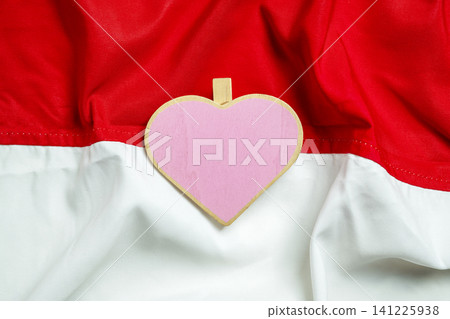 A wooden heart shape on the red and white Indonesian flag background, symbolizing patriotism, national pride, and love for Indonesia, ideal for Independence Day A wooden heart shape on the red and white Indonesian flag background, symbolizing patriotism, national pride, and love for Indonesia, ideal for Independence Day 141225938