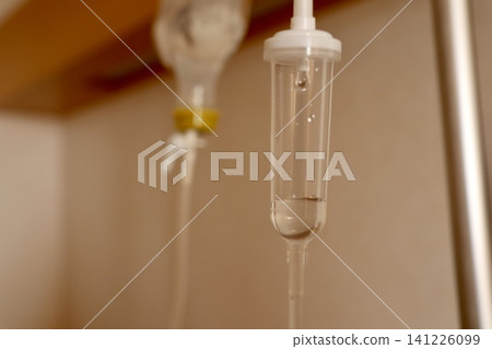 Close-up of intravenous fluid dripping into a drip chamber: A medical scene in use in a hospital room | Medical articles, hospital public relations, nursing teaching materials 141226099