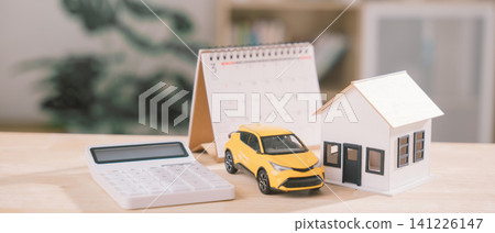 Financial planning for property investment, car loan, home insurance features calculator placed beside house model, calendar helps tracking wealth management, construction, rental, finance Financial planning for property investment, car loan, home insurance features calculator placed beside house model, calendar helps tracking wealth management, construction, rental, finance 141226147